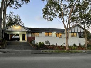 a white house with a car parked in front of it at Refurbished Family Home in Glen Waverley