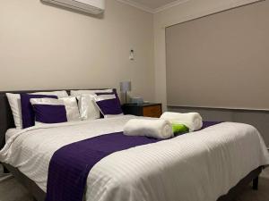 a bedroom with a large bed with purple and white sheets at Refurbished Family Home in Glen Waverley