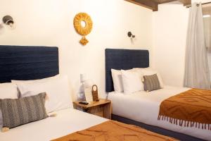 a bedroom with two beds and a mirror on the wall at Mestizo Antigua in Antigua Guatemala