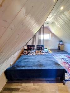 ein Schlafzimmer mit einem großen Bett im Dachgeschoss in der Unterkunft Charming Sauna Cottage in a Horse Ranch in Lieplaukė