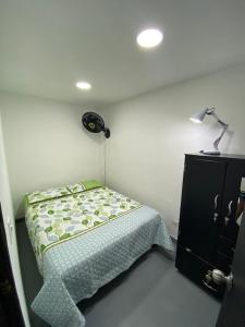Dormitorio pequeño con cama y lámpara en apartamento en Medellin, Santa Monica en Medellín