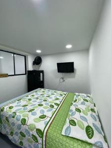 Un dormitorio con una cama con un edredón verde. en apartamento en Medellin, Santa Monica, en Medellín