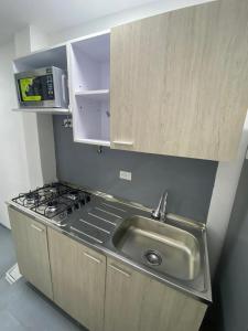 una cocina con fregadero y estufa en apartamento en Medellin, Santa Monica, en Medellín