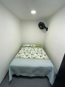 Cama pequeña en habitación con lámpara en apartamento en Medellin, Santa Monica, en Medellín