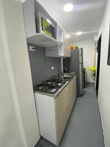 uma cozinha com um fogão e um micro-ondas em apartamento en Medellin, Santa Monica em Medellín
