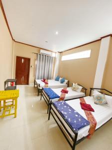 a row of three beds in a room at Ali Local Home in Vientiane