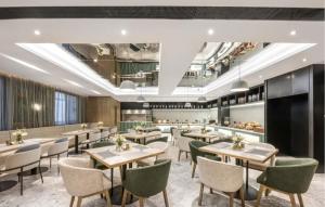 Orange Hotel - Taicang Nanyang Plaza في Taicang: مطعم فيه طاولات وكراسي في الغرفة