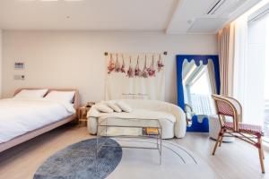 a bedroom with a bed and a table and a chair at The castle ocean suite in Yeosu