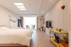 ein Schlafzimmer mit einem Bett und einem TV in der Unterkunft The castle ocean suite in Yeosu