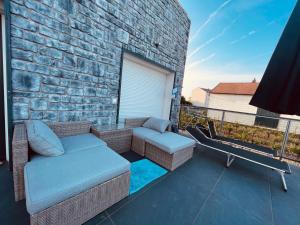 a patio with a couch and chairs on a balcony at Sandy’s Home in Neusiedl am See