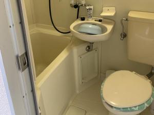 a small bathroom with a toilet and a sink at Imazato Ryokan in Osaka
