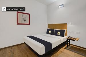 a bedroom with a large bed with blue pillows at Super Townhouse HAL Indiranagar Extension in Bangalore