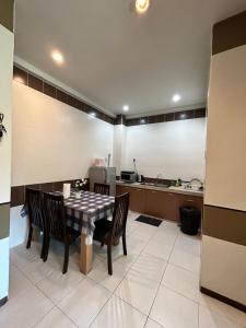 a kitchen with a table and chairs in a room at Cameron Iris AiSHomestay in Tanah Rata