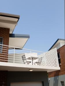 a balcony with two chairs and a table on it at Hamilton on Everton in Newcastle