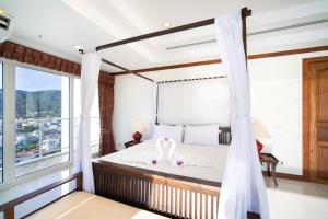 um quarto com uma cama com dois cisnes em Patongtower Duplex Seaview4BR2901 em Patong Beach