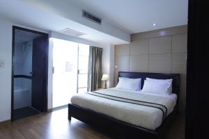 a bedroom with a large bed and a bathroom at Nanatai Suites in Bangkok
