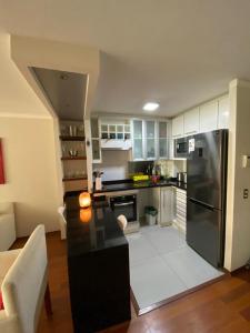 a kitchen with a black refrigerator and a table at Departamento Las Condes Mall Sport in Santiago
