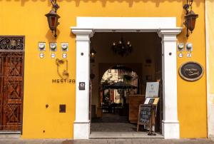 Mestizo Antigua في أنتيغوا غواتيمالا: مبنى اصفر مع مدخل للمطعم