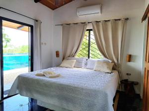 a bedroom with a bed with a large window at Casa Namaste del Pacifico - Luxury Villa in Santa Teresa Beach