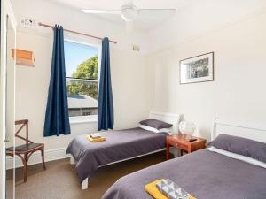 a bedroom with two beds and a window at Lord Wolseley Hotel in Sydney