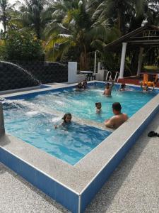 a group of people swimming in a swimming pool at Homestay sunnah bougainvillea resident Islam 