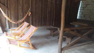 two chairs and a table and a hammock in a room at Bukska Sadyba in Buki