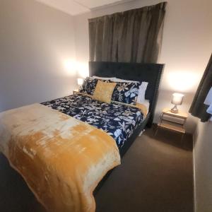 a bedroom with a bed with blue and yellow sheets at Couples Retreat in Reefton