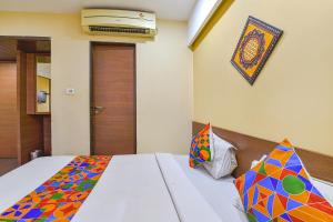 a bedroom with a bed with a colorful blanket at FabHotel RB Residency in Surat