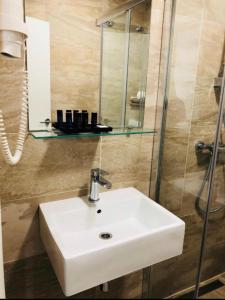 a bathroom with a white sink and a shower at Sea La Vie Rooms in Novi Vinodolski