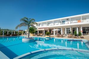 a large swimming pool in front of a hotel at Ikaros hotel in Laganas