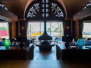 un ristorante con una grande sala con tavoli e vasi di The Luigans Spa and Resort a Fukuoka