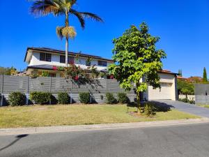 a house with a fence and a palm tree at Eight Mile Plains House in Brisbane