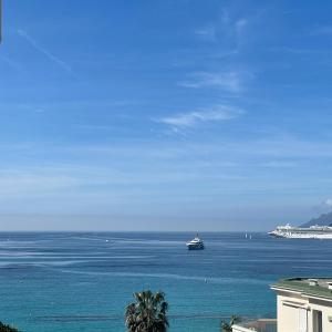 un bateau dans l'océan avec un bateau de croisière dans l'établissement CROISETTE VUE MER LATERALE, à Cannes