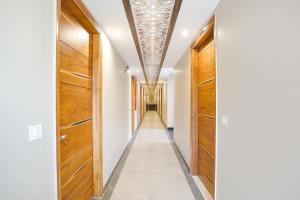 un pasillo con puertas de madera y paredes blancas en FabHotel Royale 116, en Noida