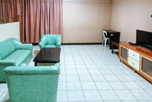 sala de estar con sofá y TV en Check Inn Bacolod by RedDoorz en Bacólod