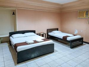 1 Schlafzimmer mit 2 Betten in einem Zimmer in der Unterkunft Check Inn Bacolod by RedDoorz in Bacolod City