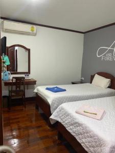 a room with two beds and a desk with a mirror at DaViKa Hotel in Vientiane