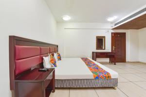 um quarto com uma cama e uma secretária. em FabHotel GL Residency em Ahmedabad