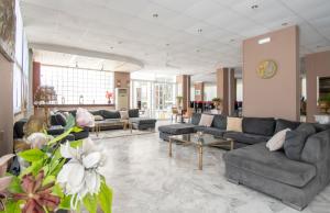 a large living room with couches and flowers in it at Ikaros hotel in Laganas