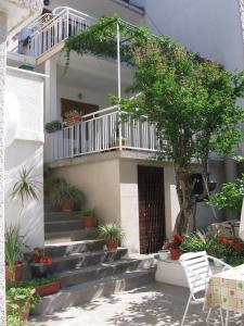 un edificio con escaleras y un balcón con plantas en Apartments Marjanovic en Bol