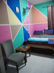 een kamer met 2 bedden en een tafel en een stoel bij Sharaf DG Metro Unisex PARTITION Private room -40-02 in Dubai