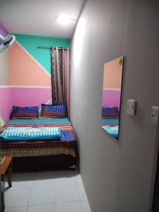 een kleine kamer met een bed en een spiegel bij Sharaf DG Metro Unisex PARTITION Private room -40-02 in Dubai