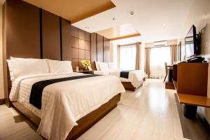 Cette chambre comprend deux lits et une télévision. dans l'établissement ECL Resort Hotel Boracay, à Boracay