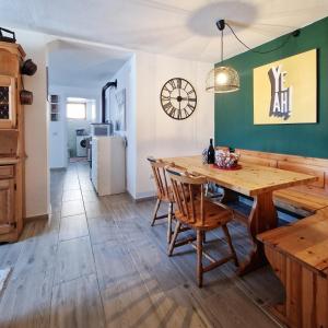 een keuken en eetkamer met een houten tafel en stoelen bij Casa Polsa "1964" in Brentonico