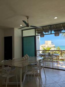 a dining room with a table and chairs and a balcony at Departamento El Cardumen in Chicxulub
