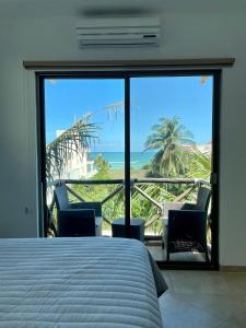 a bedroom with a bed and a view of the ocean at Departamento El Cardumen in Chicxulub +18 photos