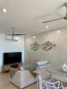 a living room with a couch and a flat screen tv at Departamento El Cardumen in Chicxulub