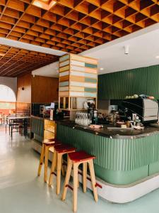 a kitchen with wooden stools and a counter top at Mr A Hotel in Bandung