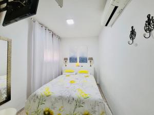 アルムニェーカルにあるEl Balcón del Marの白いベッドルーム(黄色い枕のベッド付)