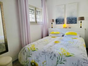 アルムニェーカルにあるEl Balcón del Marのベッドルーム1室(花柄のベッドカバー付)